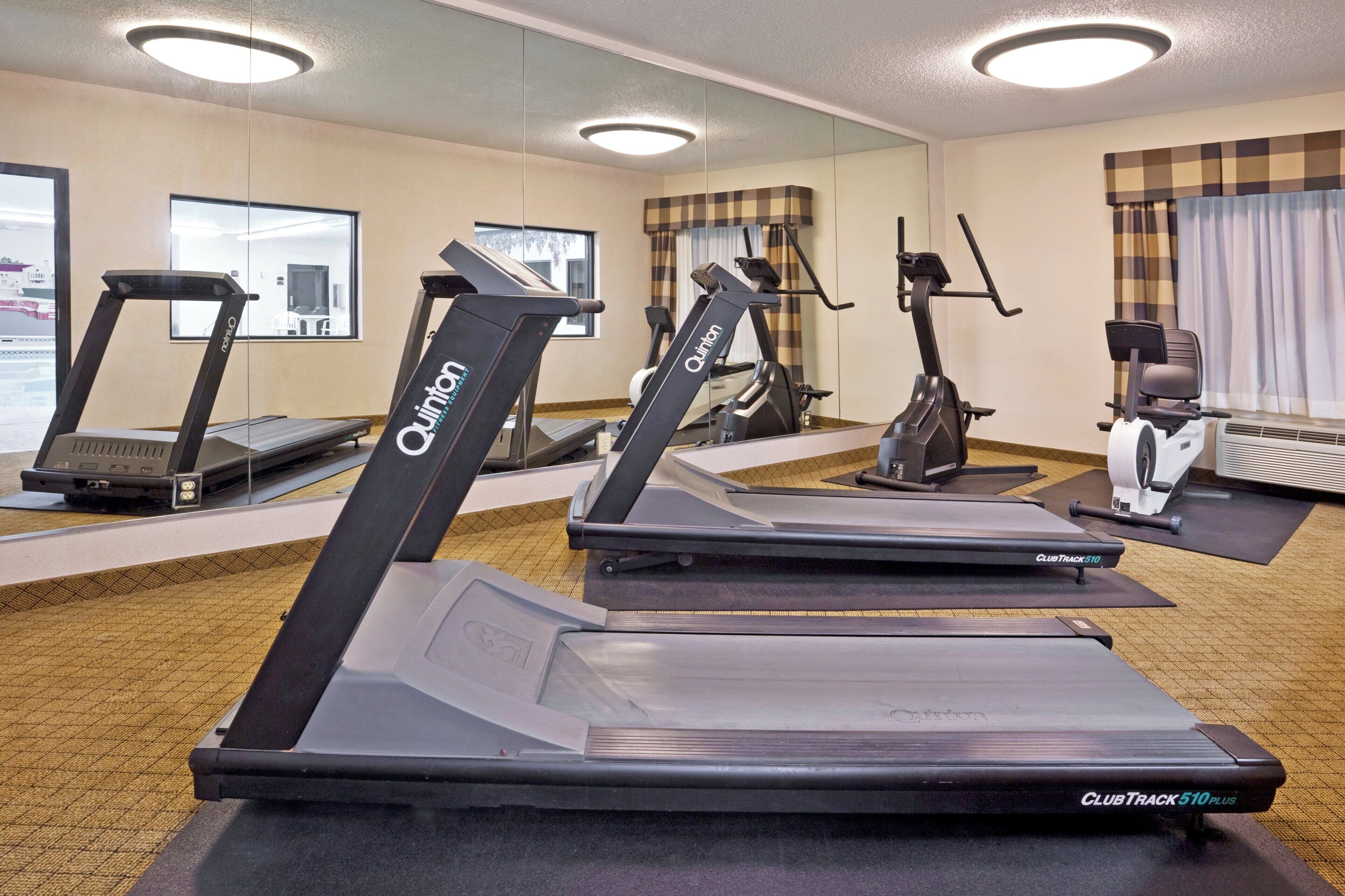 Una palestra alberghiera dotata di diverse tapis roulant, cyclette e un vogatore.