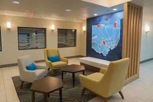 Un vestíbulo con zona de estar, un mapa en la pared y una recepción.