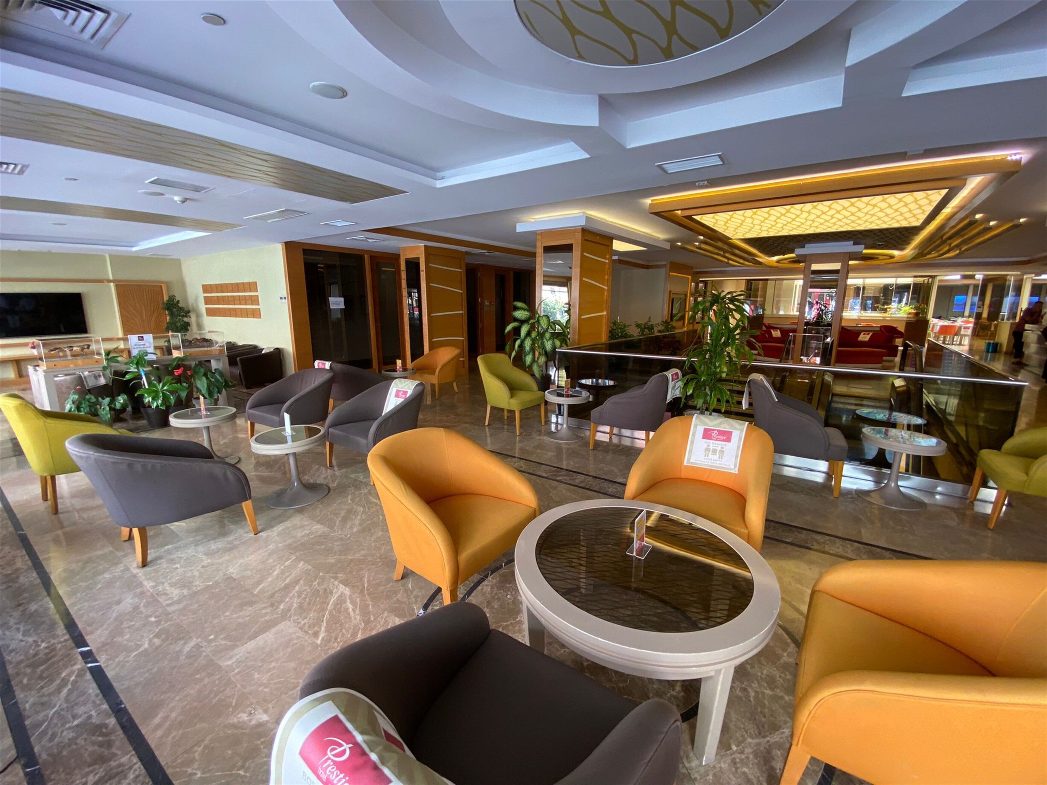 A modern lobby with seating areas, a reception desk, and a bar.