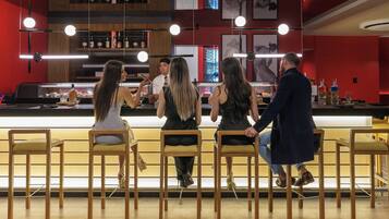 Zona de bar con sillas de madera y una barra.