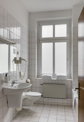 A bathroom with a white sink, toilet, and a window with a view. - Hotel Nova Berlin (Berlin)