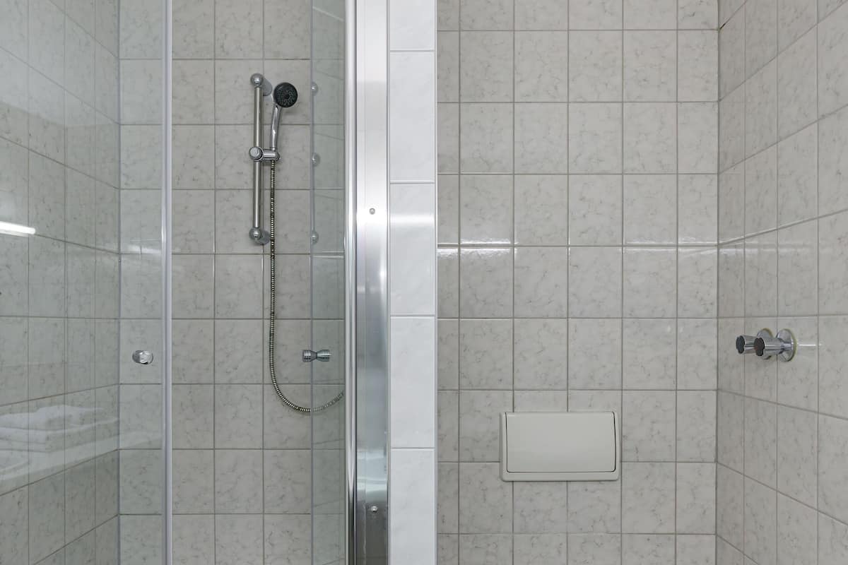 Une salle de bain moderne dotée d’une douche à parois de verre, de toilettes et d’un bidet.