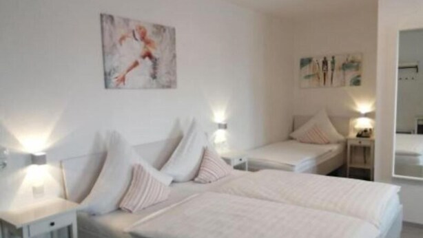 A modern bedroom with a large bed, bedside tables, and wall-mounted artwork. - To Be Deleted - Hotel Princess (Rodenbach)