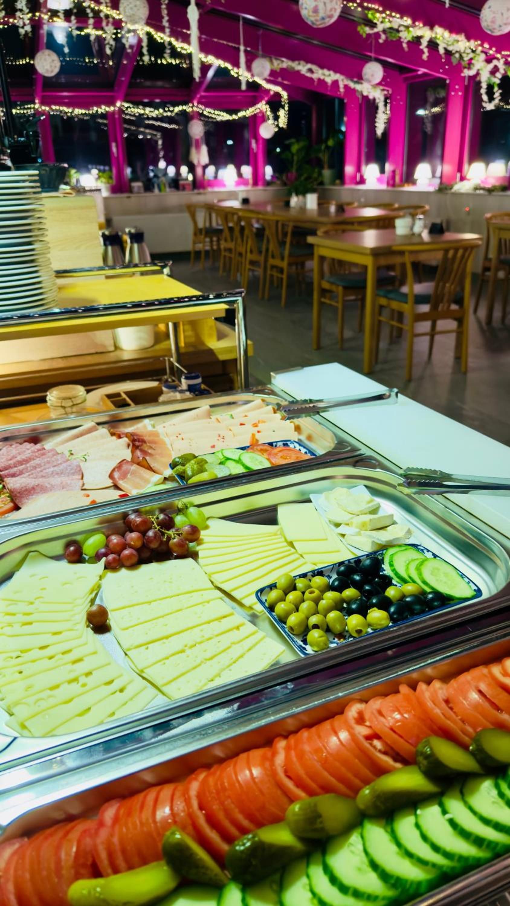 Un bufé con diversos alimentos, incluyendo queso, carnes y frutas.