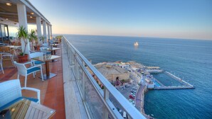 A terrace with outdoor seating, overlooking a marina and the sea. - The Preluna Hotel (Sliema)