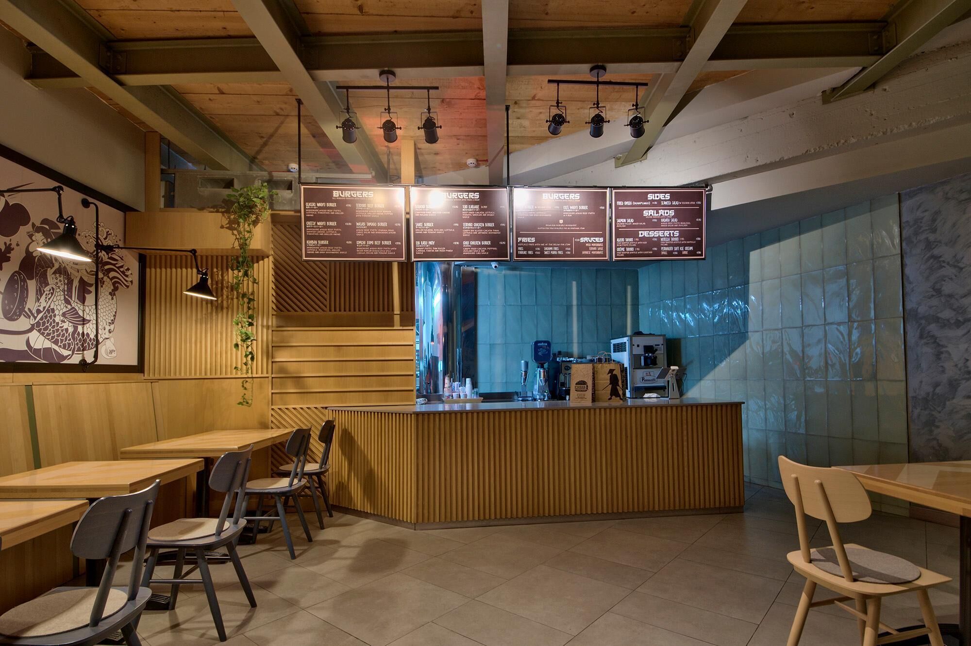 Ein Restaurantinneres mit Holztischen und -stühlen, einer Theke mit einer Speisekarte und einer Wand mit Wandmalerei.