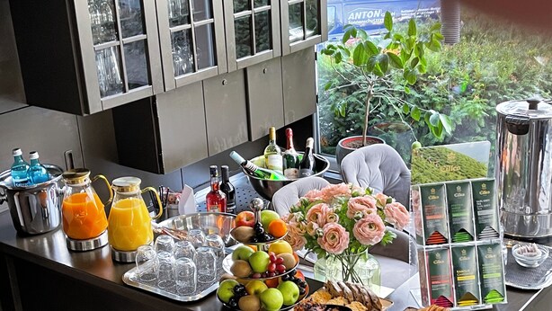 Un bufé de desayuno con diversas opciones de comida y bebidas, y vista a zonas verdes al exterior.