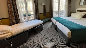 A hotel room with two beds, patterned floor, large windows, and a balcony. - Hôtel Elysa - Luxembourg (Paris)