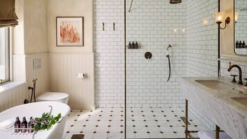 A bathroom with a freestanding bathtub, a shower enclosure, a toilet, and a vanity with a mirror.