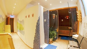 Ett hotellrum med en böjd vägg, ett stort fönster, en växt och en sittgrupp med stolar och ett bord.