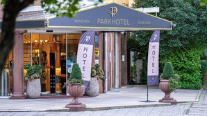 En hotellentréd med en skylt som visar texten: ”Parkhotel München – njut av vistelsen”.