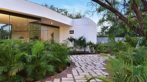 A modern building with a spa sign, surrounded by lush greenery and a stone pathway. - Radisson Hotel Khajuraho (Rajnagar)