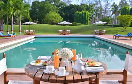 Una piscina al aire libre, sillones reclinables de piscina
