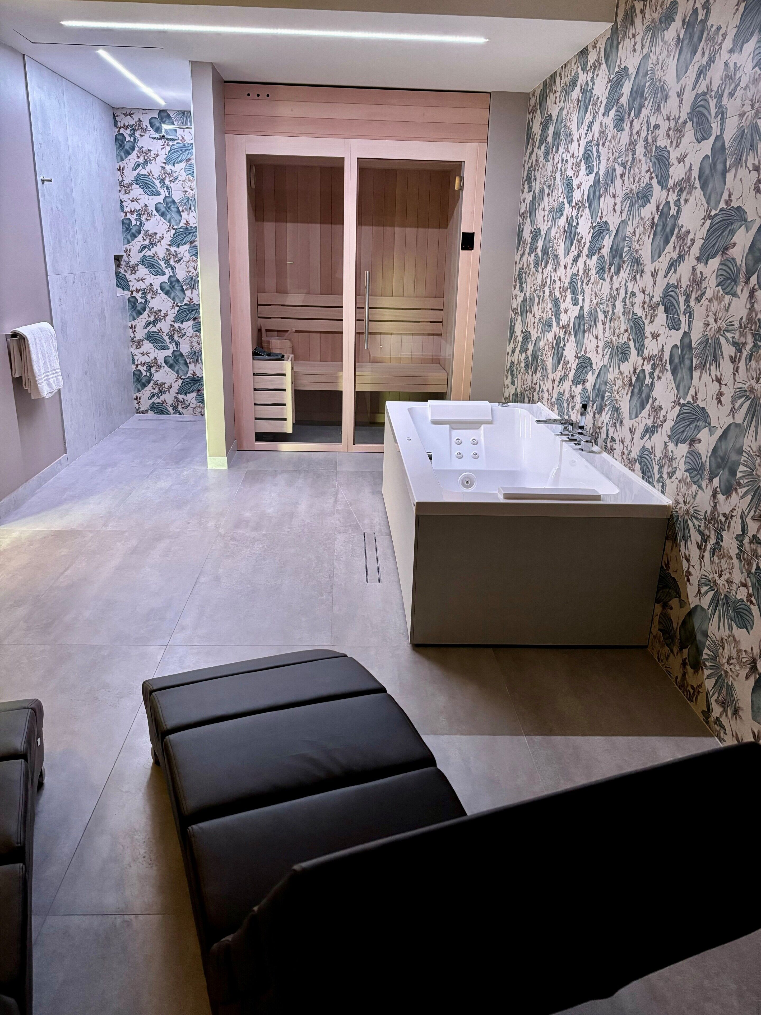 Un baño moderno con una bañera grande, armarios de almacenamiento de madera y una zona de ducha.