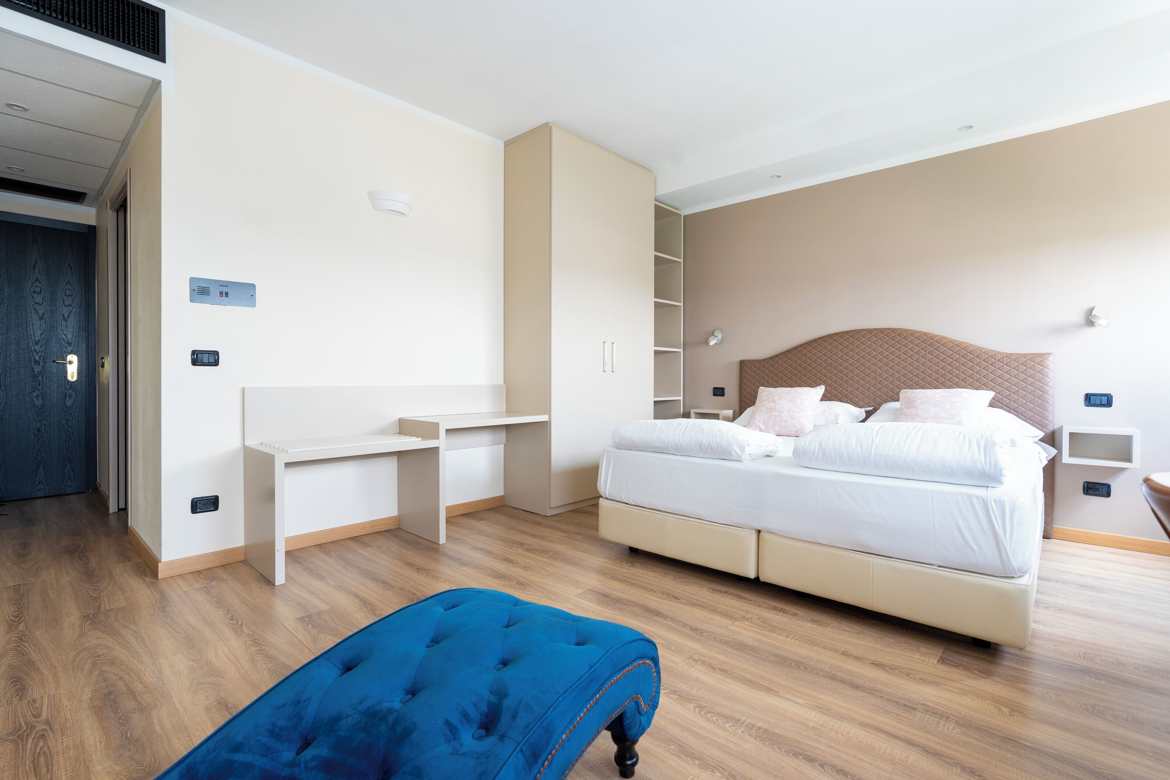 Habitació d'hotel moderna amb un llit, escriptori i armari.