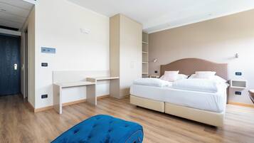Habitació d'hotel moderna amb un llit, escriptori i armari.