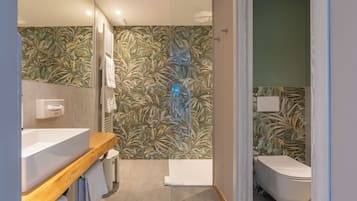 Un baño moderno con tocador de madera, inodoro y bañera.