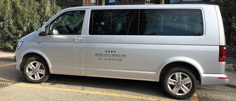 A silver van parked in front of a building with a sign that reads "HOTEL SACCARDI & SPA."