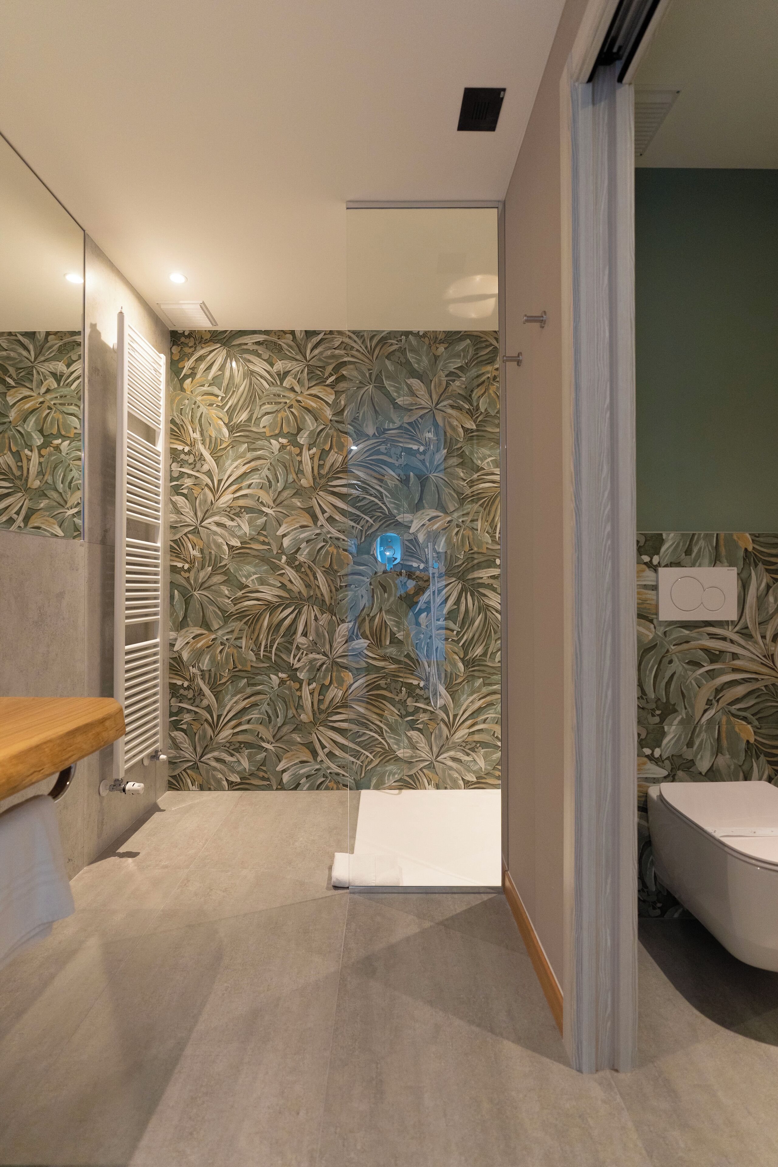 Un baño moderno con un espejo grande, una bañera y una zona de ducha.