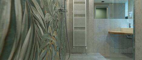 A modern bathroom with a glass shower enclosure, a towel rack, and a mirror.