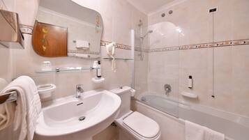 Een badkamer met wastafel, toilet en bad.
