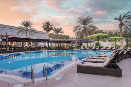Outdoor pool, pool umbrellas, sun loungers. Radisson Blu Hotel, Muscat