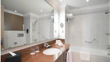 Une salle de bain moderne avec un grand miroir, un lavabo, une baignoire et un espace douche.