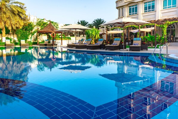 Piscine extérieure, parasols de plage, chaises longues