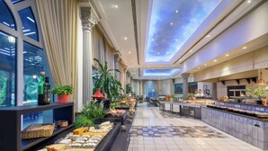 A hotel lobby with a buffet, large windows, and a ceiling with a light design. - Radisson Blu Hotel, Muscat (Muscat)