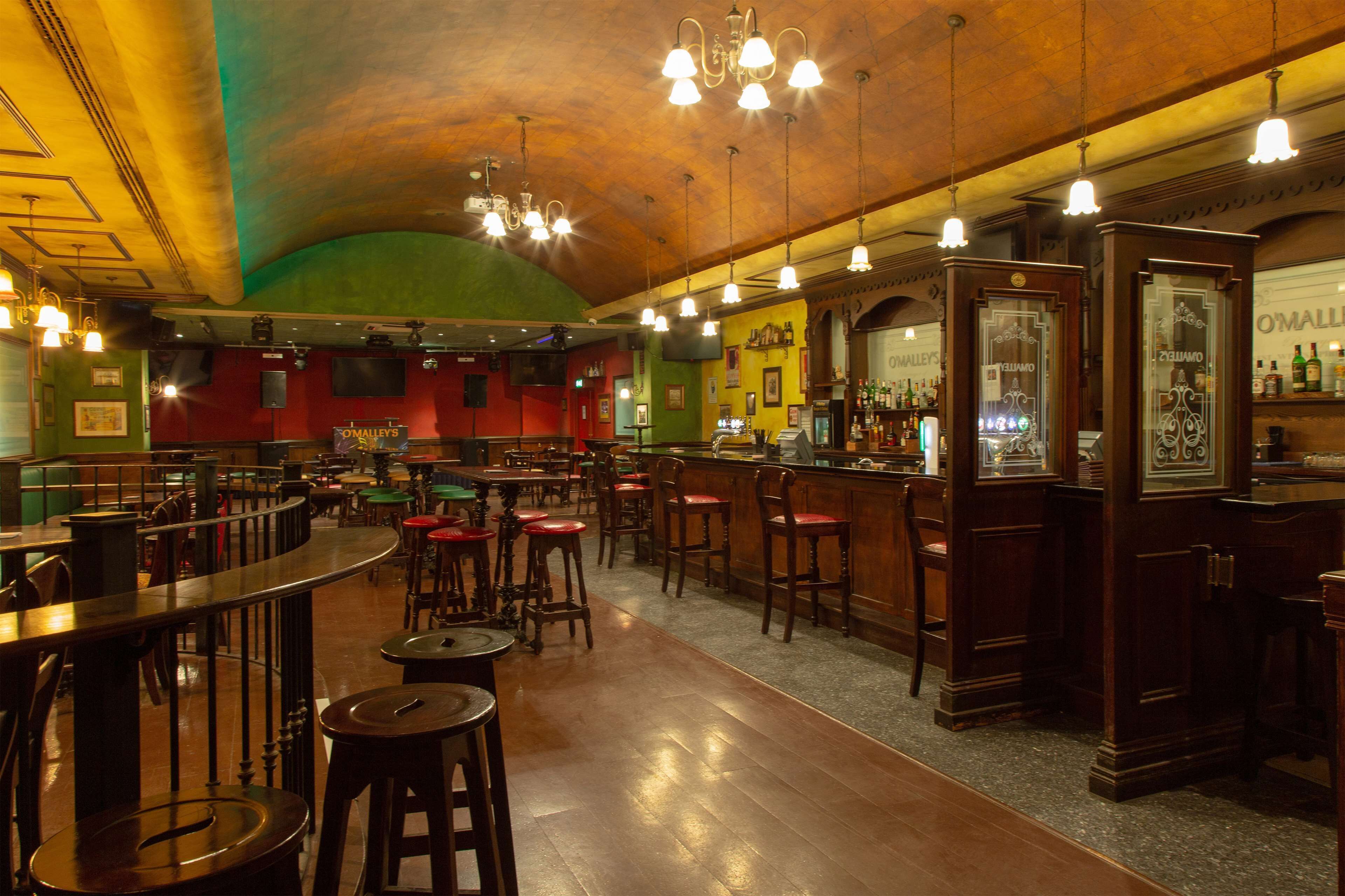 A spacious bar area with multiple seating options, including high stools and bar stools, and a variety of bar counters.