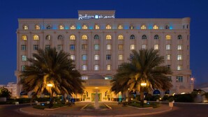 A large, multi-story hotel with a prominent sign in Arabic.