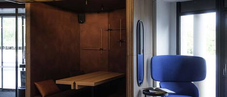 A modern room with a wooden table, blue chair, and a unique ceiling design.