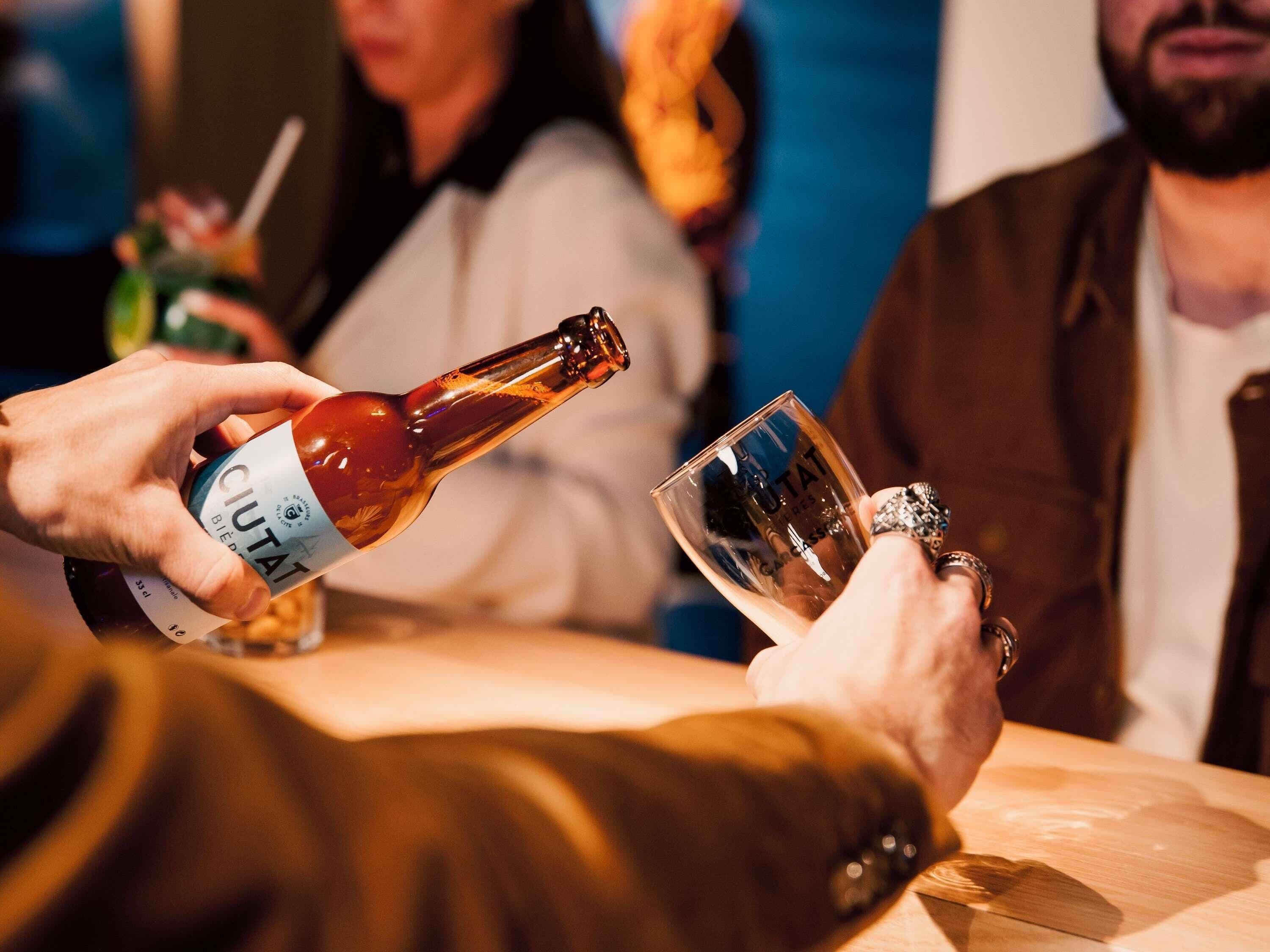 A person pouring a bottle into a glass.