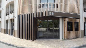 A modern building with a sign reading "TRIBE" at the entrance.