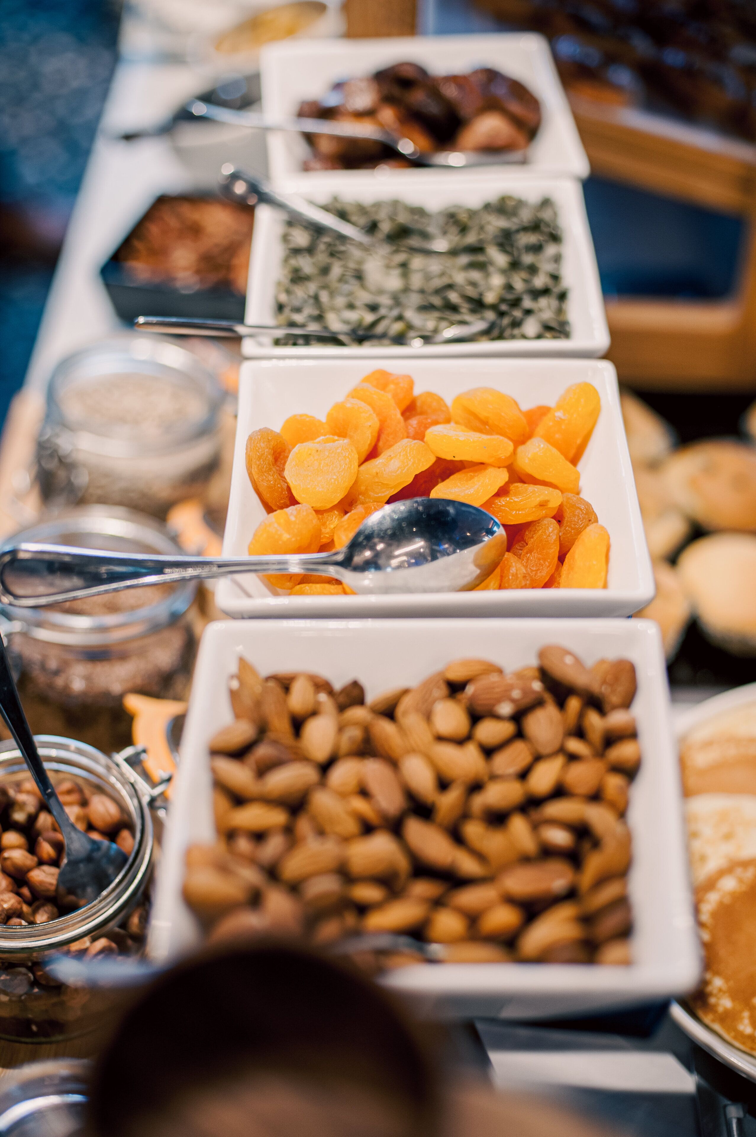 A buffet table with various food items including fruits, nuts, and other snacks.