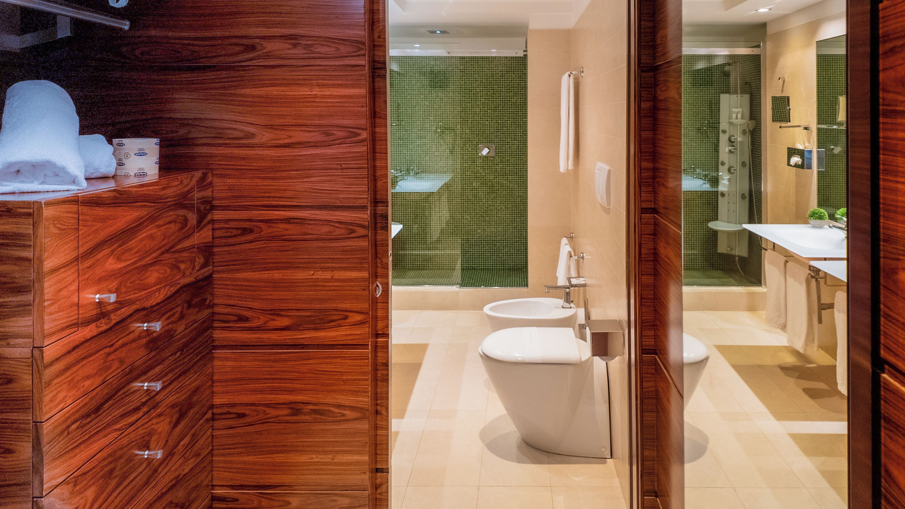 A modern bathroom with a wooden vanity, a toilet, and a shower area.