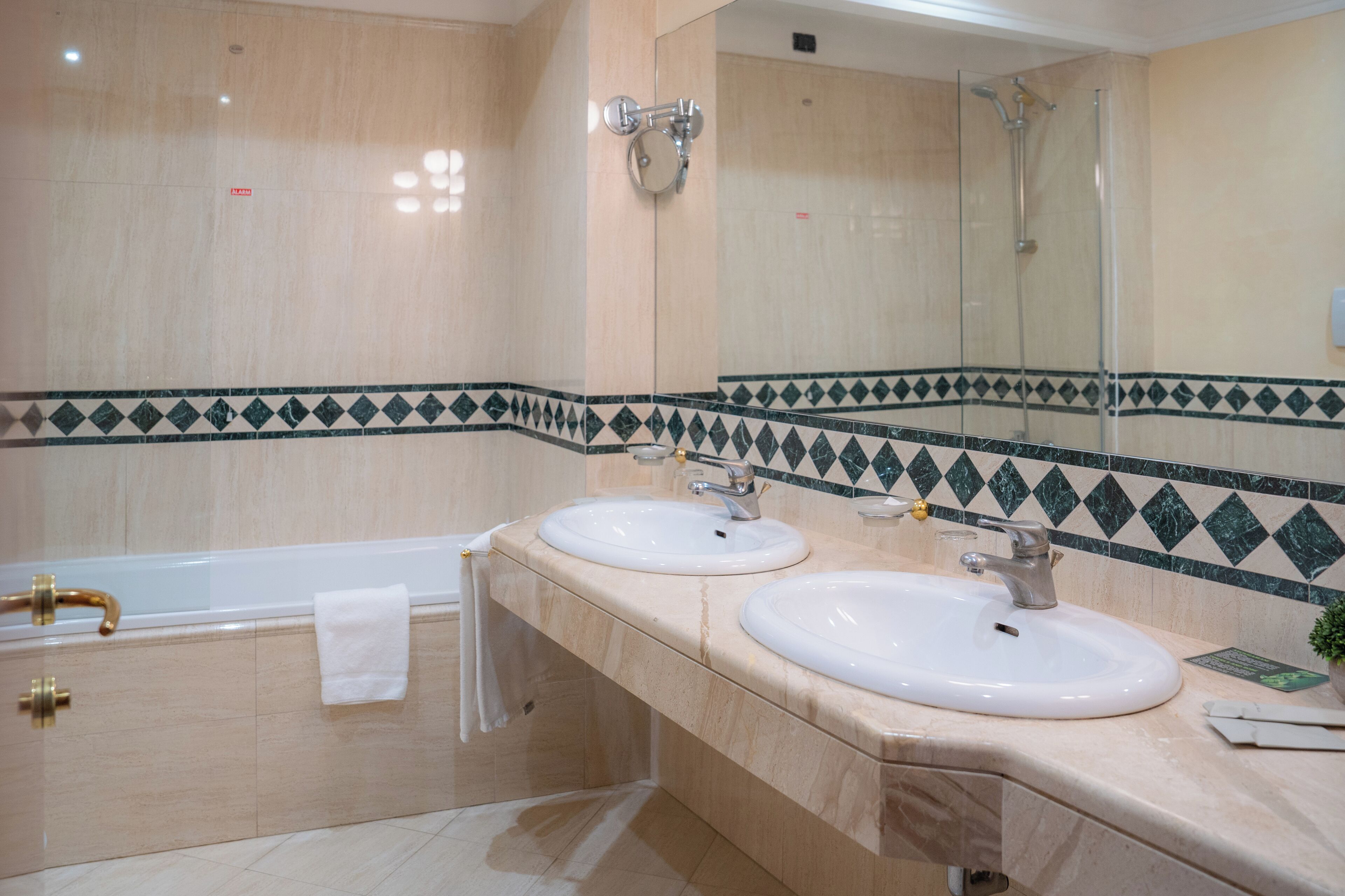 Une salle de bain avec deux lavabos, une baignoire et une douche.