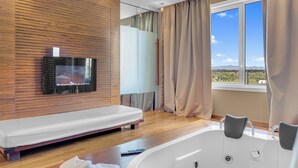 A modern bathroom with a bathtub, a vanity, and a large window with a view of the landscape. - Hotel Roma Aurelia Antica (Rome)