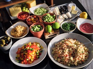 A table with various food items including cheese, olives, and salads. - Flemings Hotel Frankfurt Main-Riverside (Frankfurt)