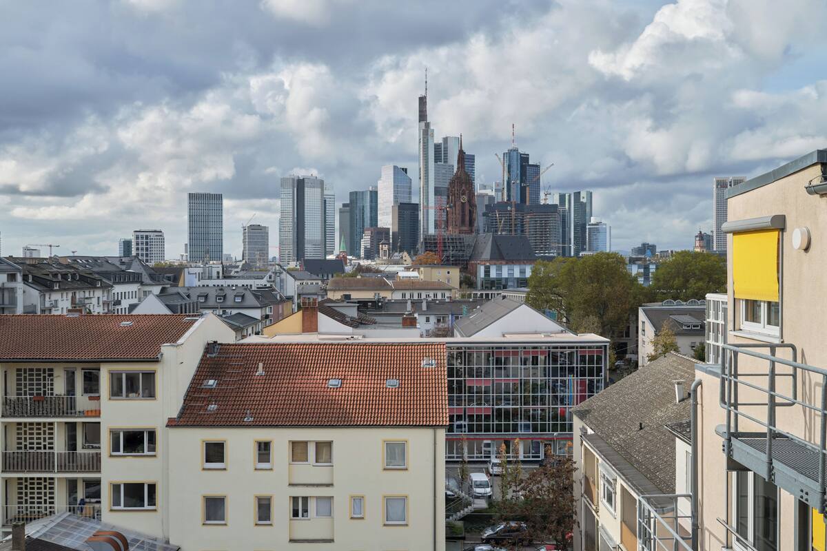 A cityscape with a mix of modern skyscrapers and traditional buildings, including a prominent church spire.