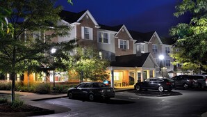 A residential area with houses, a parking lot, and a well-lit entrance. - Towneplace Suites by Marriott East Lansing (East Lansing)