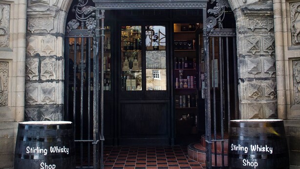 A stone archway entrance to Stirling Whisky Shop with two barrels labeled "Stirling Whisky Shop" on either side. - The Stirling Highland Hotel (Stirling)