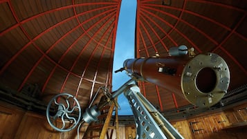 A large telescope with a wooden structure and red beams.