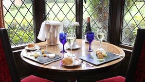 A table set for a meal with a pitcher, wine glasses, and plates of food. - Nailcote Hall Hotel (Solihull)