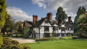 A Tudor-style house with a well-maintained garden and a gravel driveway. - Nailcote Hall Hotel (Solihull)