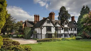 Traditional Tudor-style house with a picturesque garden and historic architecture.