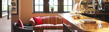 Una habitación acogedora con un sofá a rayas, una barra de madera y una ventana con vistas.