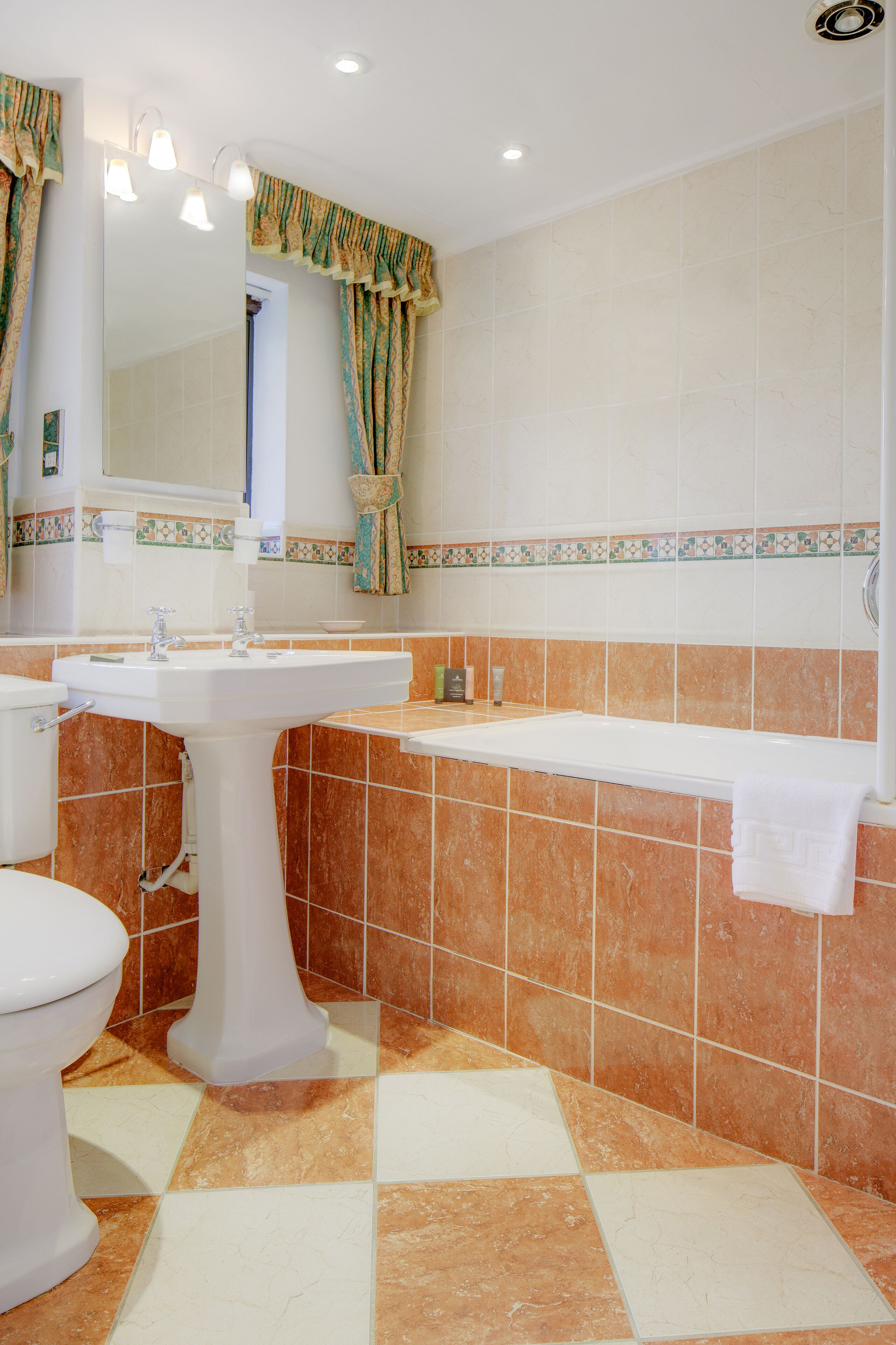 A bathroom with a pedestal sink, a toilet, and a bathtub.