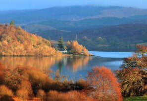 A serene lake surrounded by autumn-colored trees and hills. - Taychreggan, Signature Collection by Eight Continents (Taynuilt)