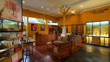 A spacious interior with wooden floors, a seating area, and a display of products.
